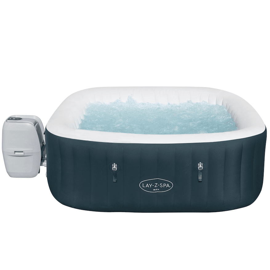 Jacuzzi en terraza de piedra junto a un chalet con bosque de montaña.